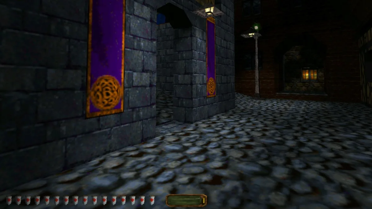 Dark cobblestone street between stone buildings at night, purple banners on the wall and a lit street lamp ahead
