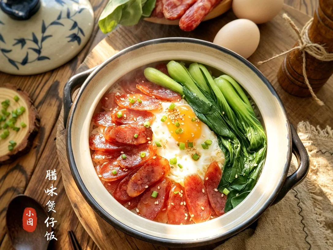 A claypot of rice topped with a fried egg, soy-glazed sausage slices and greens, sesame seeds scattered over