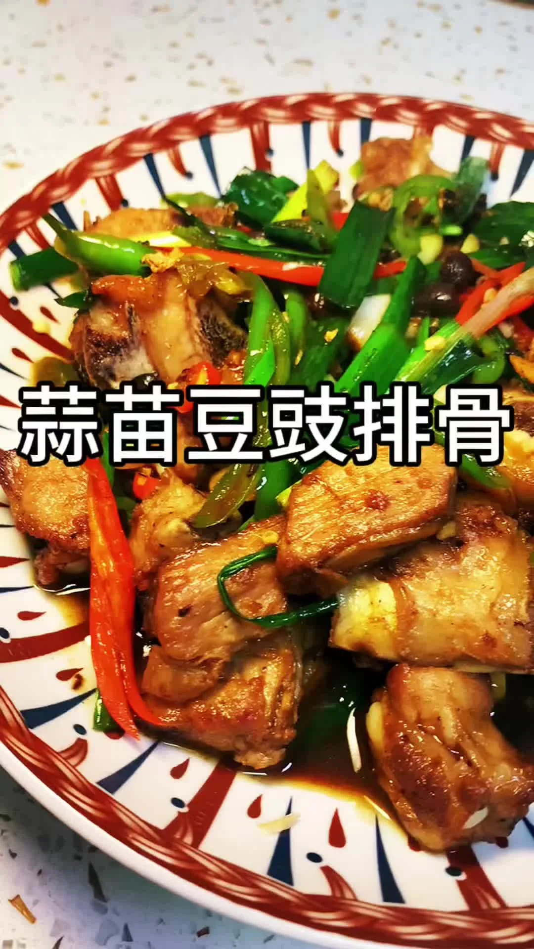 A plate of glossy fried pork ribs tossed with green garlic sprouts and black beans