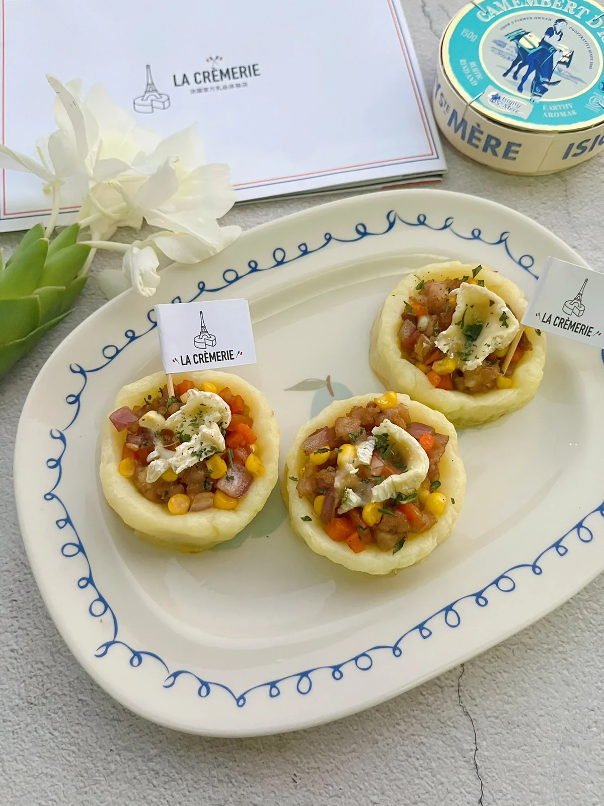 Baked potato halves filled with pork and corn, topped with melted camembert