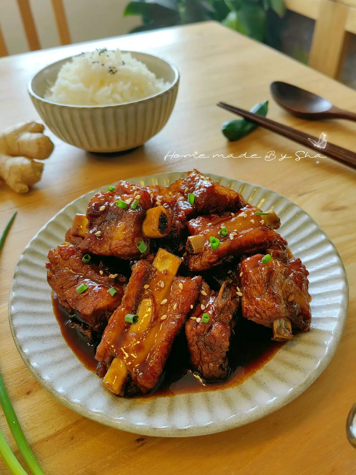 Glossy sweet and sour ribs piled on a plate and scattered with white sesame