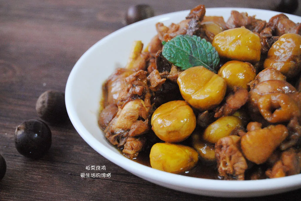 Braised chicken pieces and peeled chestnuts in dark sauce in a white bowl