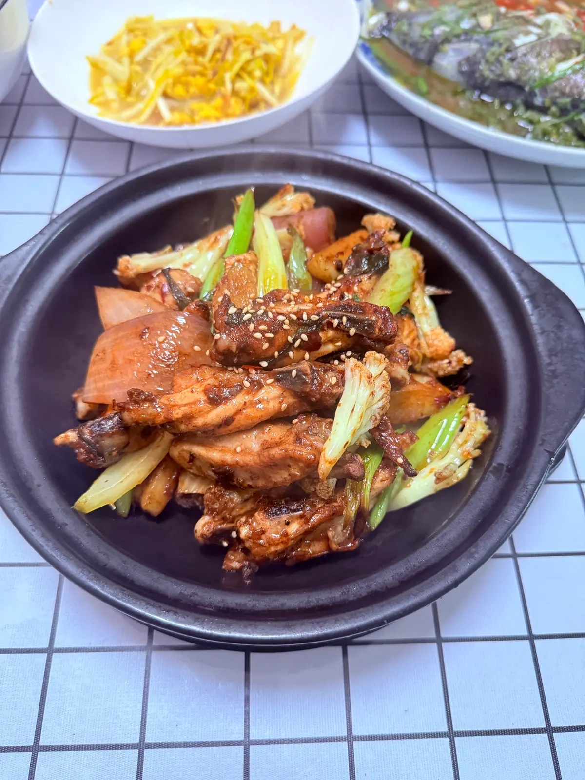 Chicken wings and vegetables coated in chilli bean sauce in a dry pot