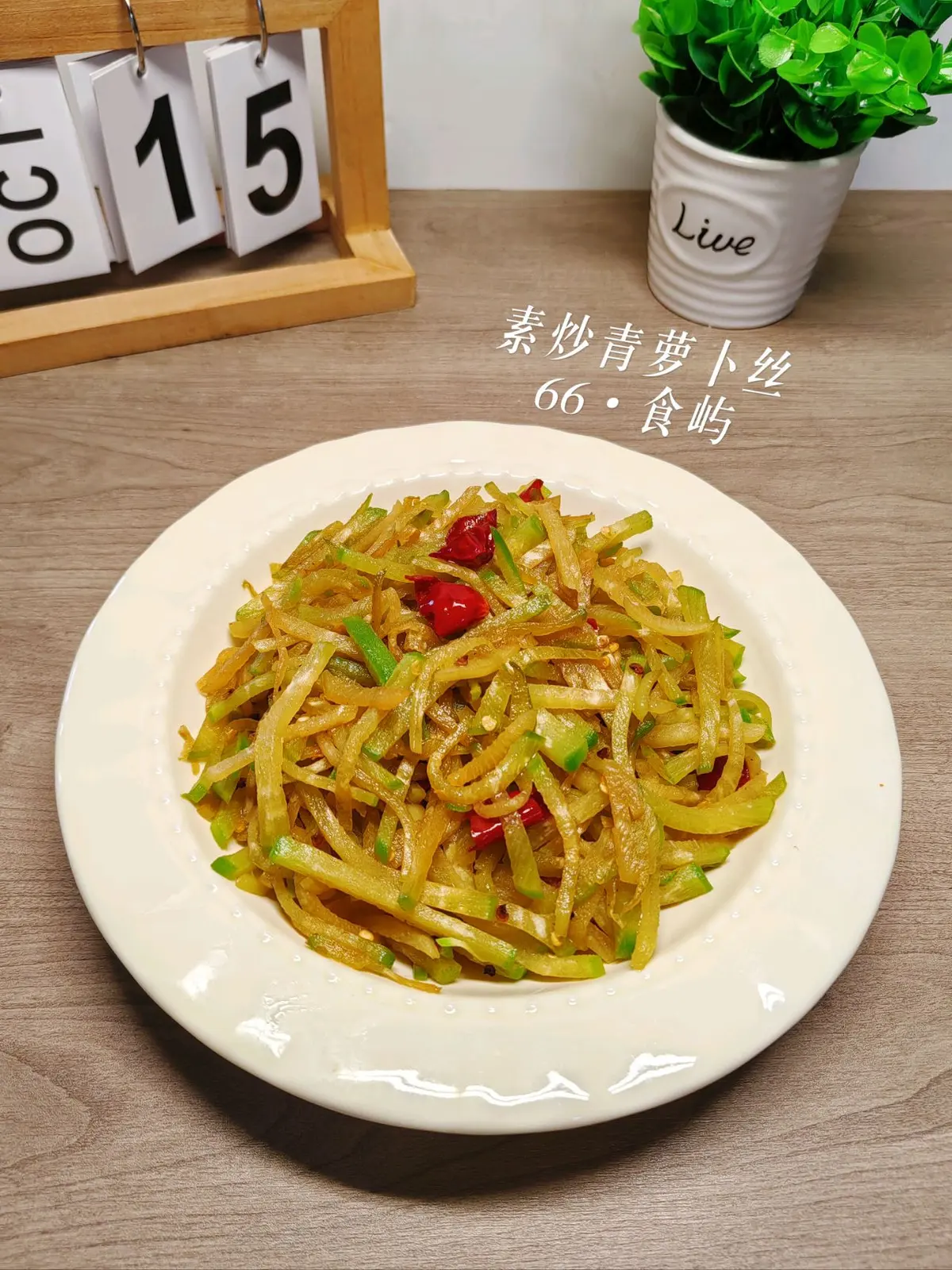 A plate of translucent shredded green radish flecked with dried chili and ginger slices