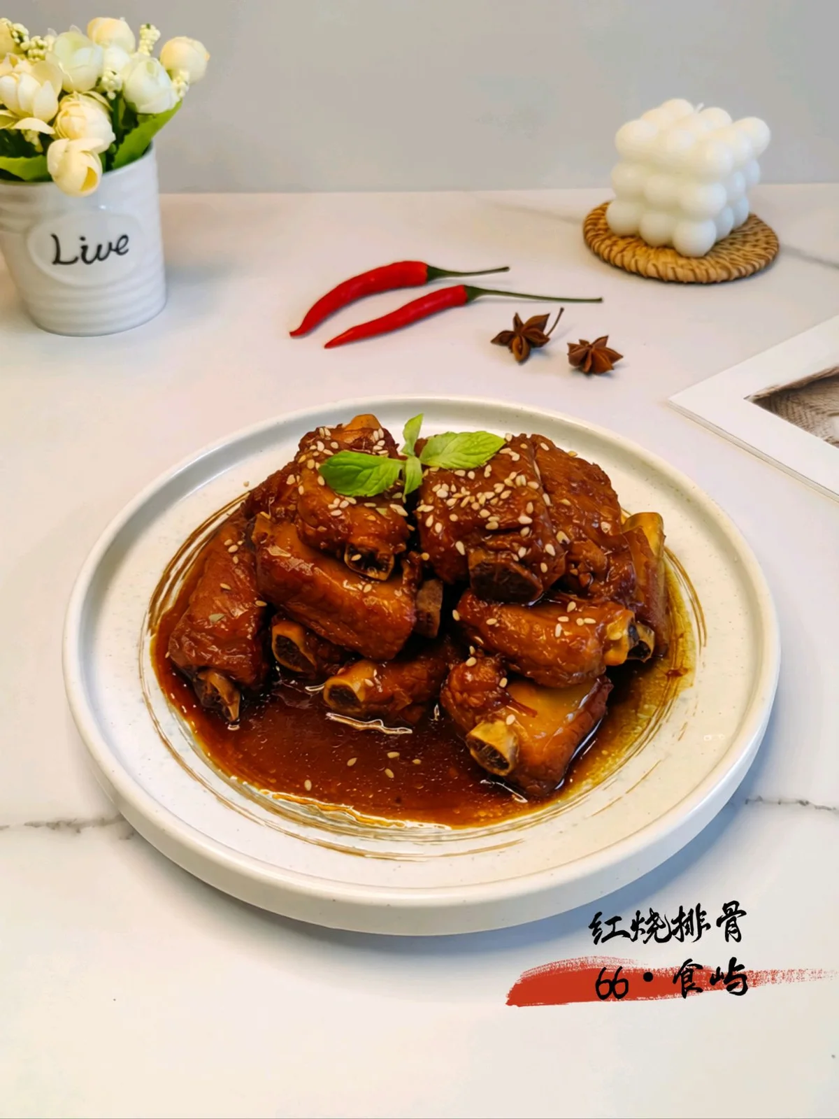 Mahogany red braised pork ribs on a white plate, glossy sauce pooled around them, sesame seeds and a mint sprig on top
