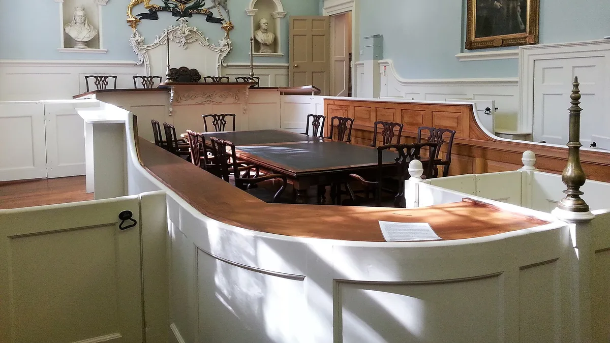 Empty courtroom with a judge's bench and rows of seating